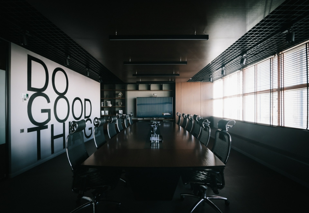 Empty board room and board table with Do Good Things painting on wall.